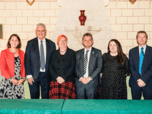 Three men and three women standing in a row, smiling.